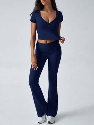Dark blue ruched waistband flared lounge pants and v-neck twist front crop top.