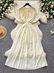Apricot floral tie-waist maxi dress with puff sleeves and gathered neckline.