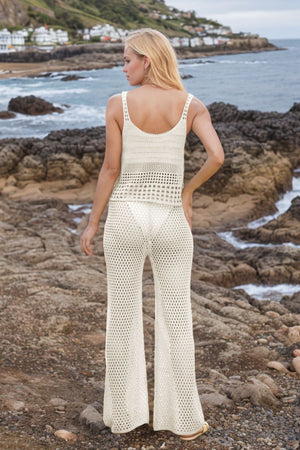 Open-knit crochet tank and flare trouser set in beige with a scoop neck and wide leg.