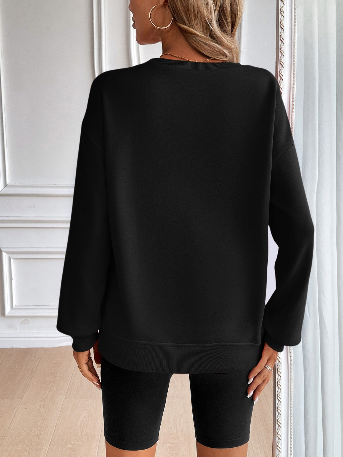 Black relaxed fit crewneck sweatshirt with long sleeves and ribbed cuffs and hem.