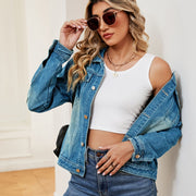 Faded wash denim trucker jacket with button closure and classic collar.