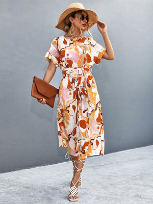 Women's abstract print midi dress with tie waist and short sleeves in orange-red and blue tones.