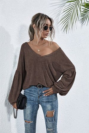 Off-shoulder knit top in mocha with blouson sleeves and V-neck.