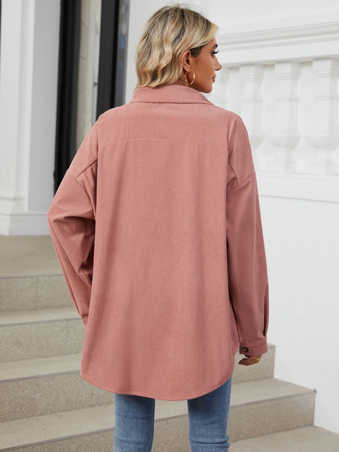 Oversized corduroy shirt jacket in dusty pink with buttoned cuffs and collar.