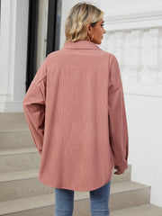Oversized corduroy shirt jacket in dusty pink with buttoned cuffs and collar.