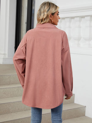 Oversized corduroy shirt jacket in dusty pink with buttoned cuffs and collar.