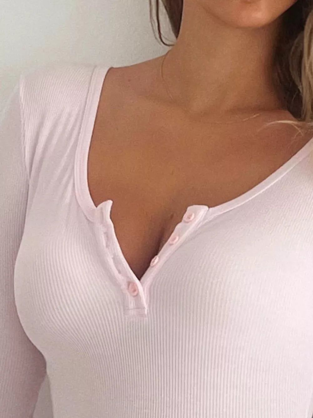 Pink ribbed knit long sleeve bodysuit with button detail