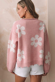 Blush pink knit sweater with white floral print and pearl embellishments on sleeves.