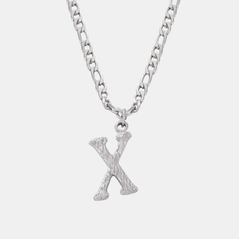 Textured initial pendant necklace in silver with a figaro chain, showing the letter X.