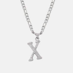 Textured initial pendant necklace in silver with a figaro chain, showing the letter X.