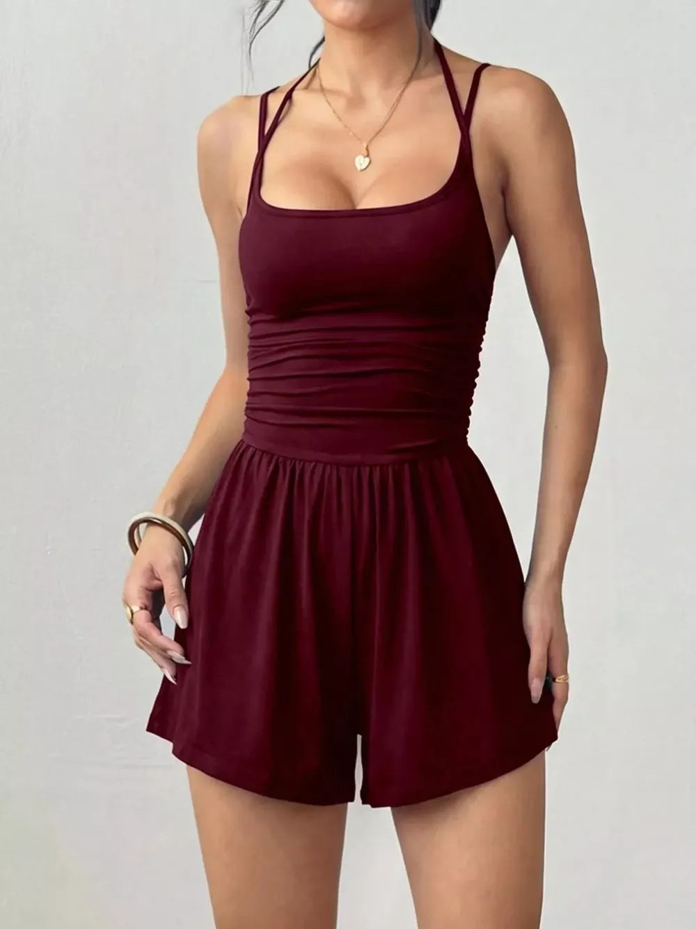Burgundy ruched spaghetti strap romper with a square neckline and gathered waist detail.