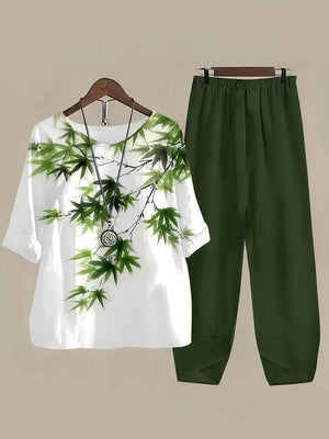 White floral print half sleeve top and dark green pants set with necklace.