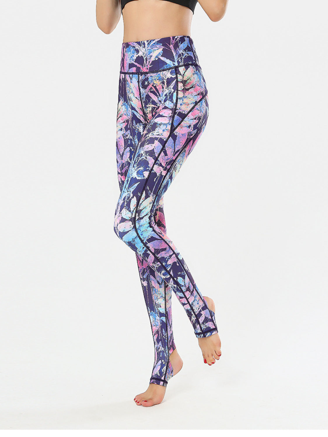 Prism Palm stirrup leggings in multi-color leaf print with black trim.