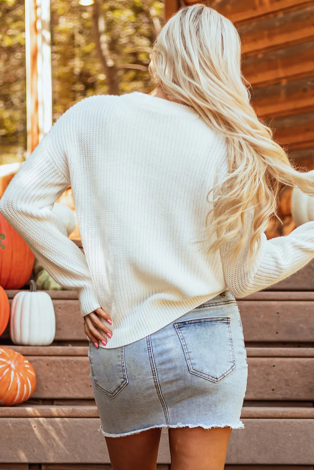 White acrylic crewneck sweater with ribbed texture and crew neckline.