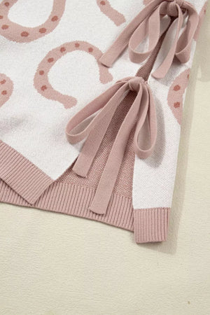 Knit top with western horseshoe print, pink ties, and ribbed trim.