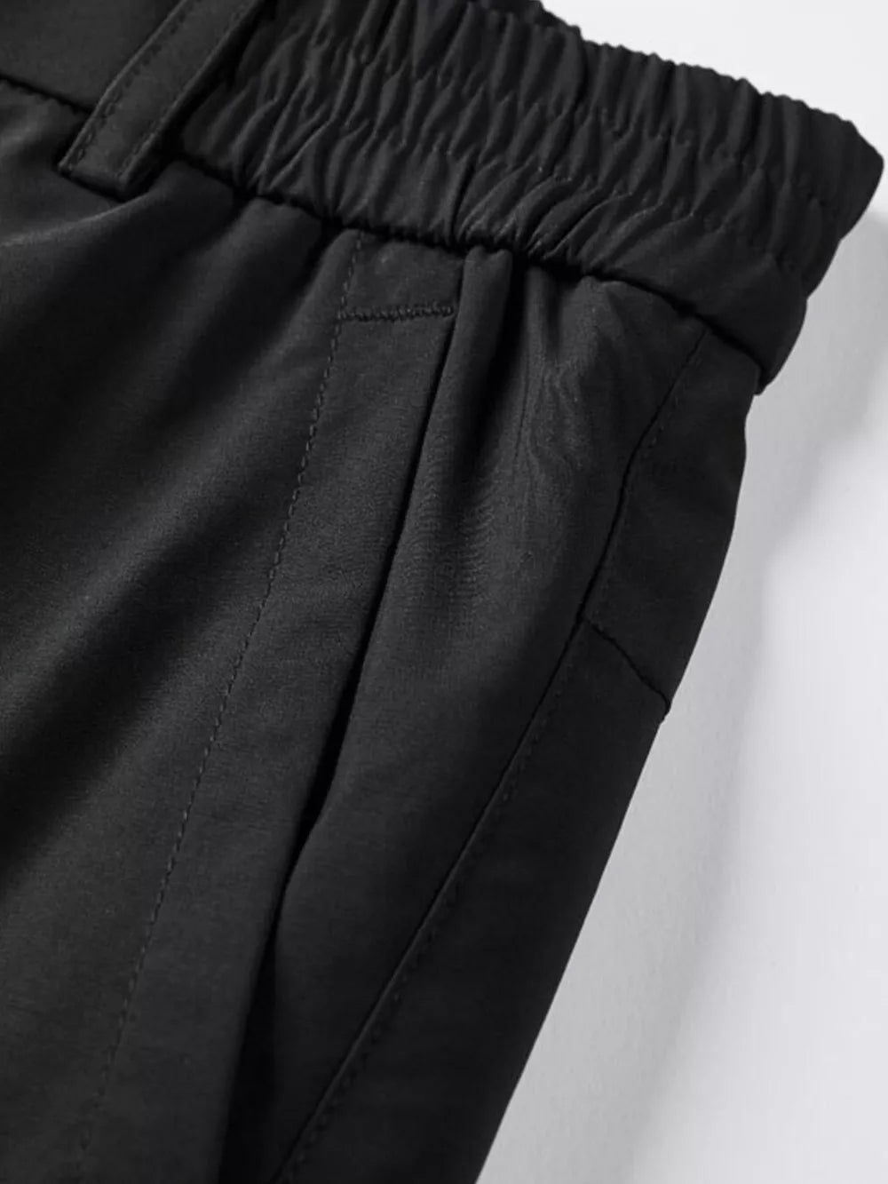 Black cargo pants with elastic waistband and side pockets.