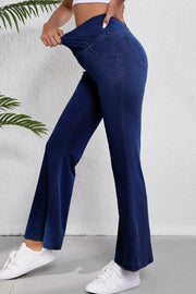 Medium wash denim flare trousers with a crossover waist detail.
