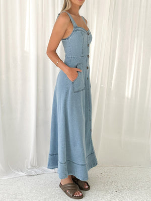 Light wash denim A-line midi dress with button front, square neckline, and patch pockets.