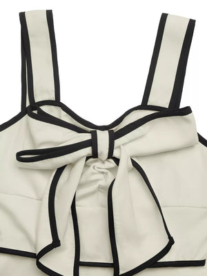 Beige A-line midi dress with black trim and bow detail at neckline