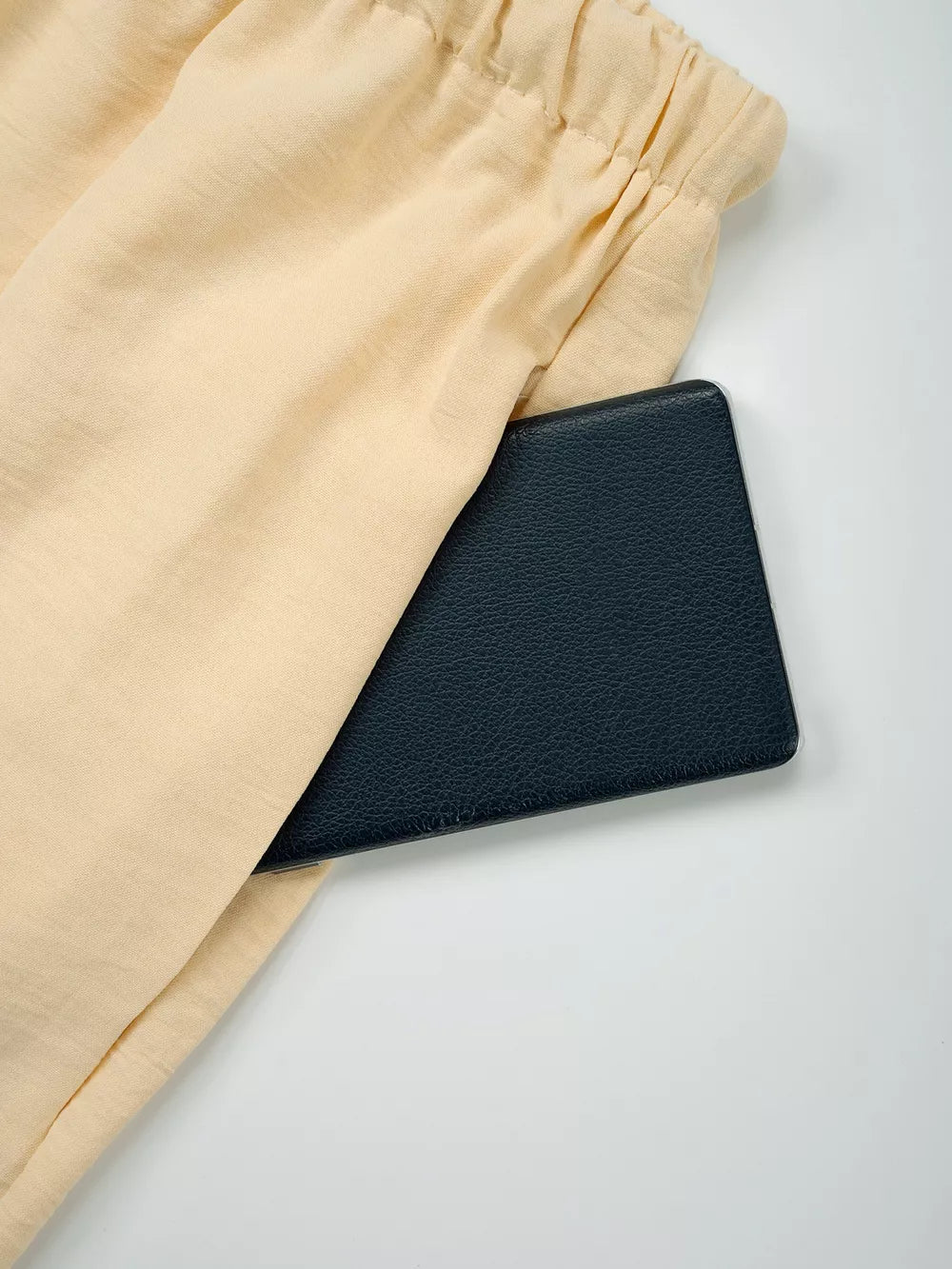 Pastel Yellow maternity pants with drawstring waist and a pocket holding a black wallet.