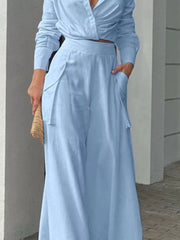 Light blue polyester two-piece set with pocketed wide-leg pants and a long-sleeve crop top.