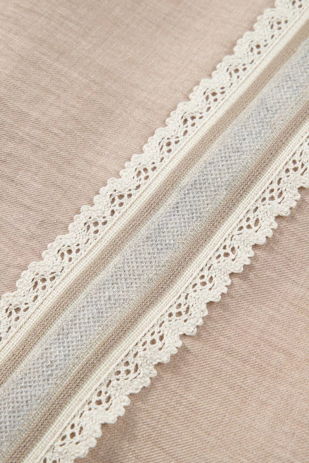 Luxe crochet lace pullover in beige with cream lace trim and a textured gray stripe detail.