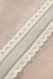 Luxe crochet lace pullover in beige with cream lace trim and a textured gray stripe detail.