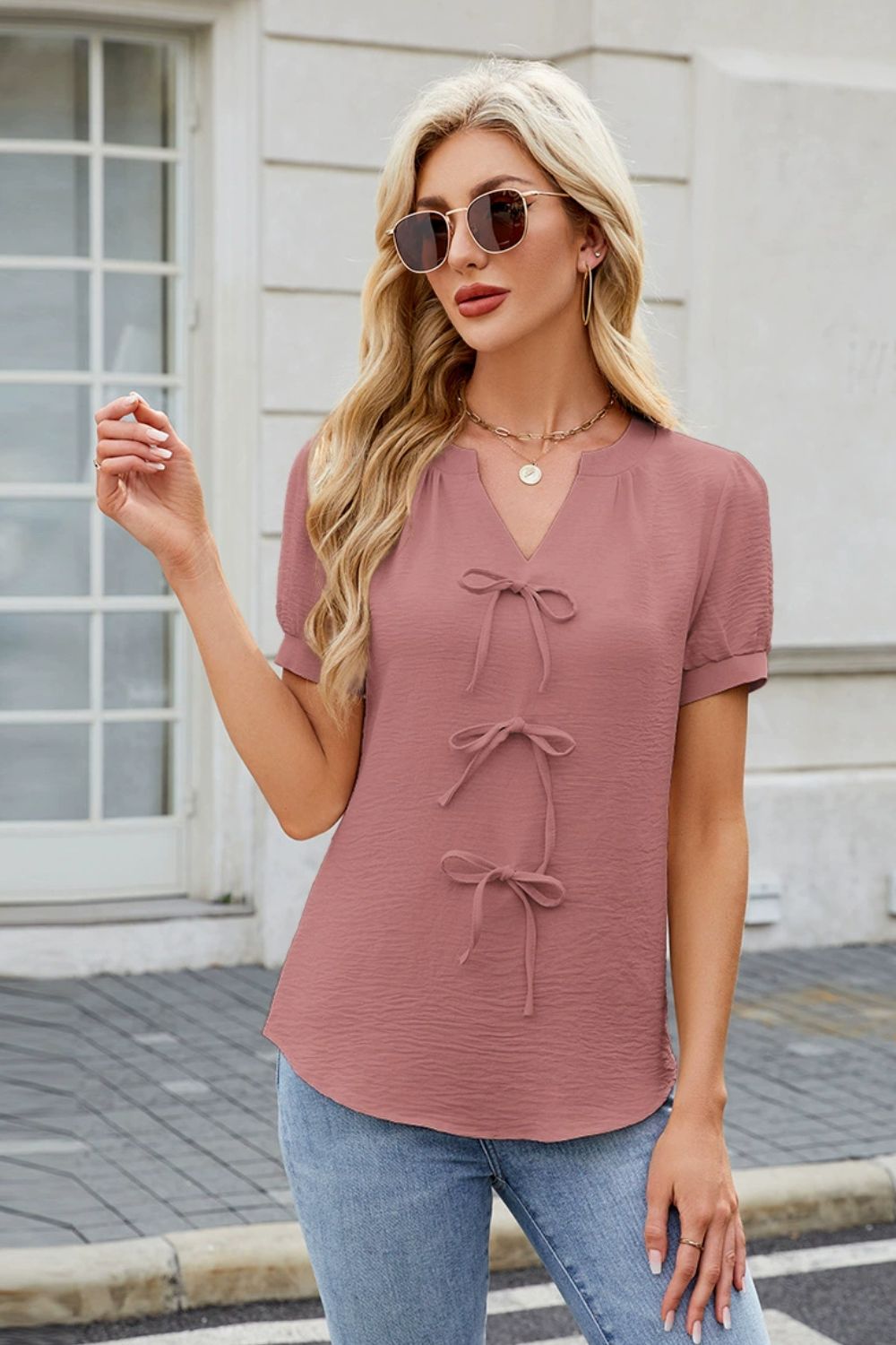 Dusty pink textured blouse with V-neck and three bow-tie details