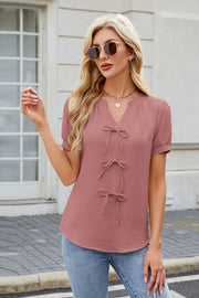 Dusty pink textured blouse with V-neck and three bow-tie details