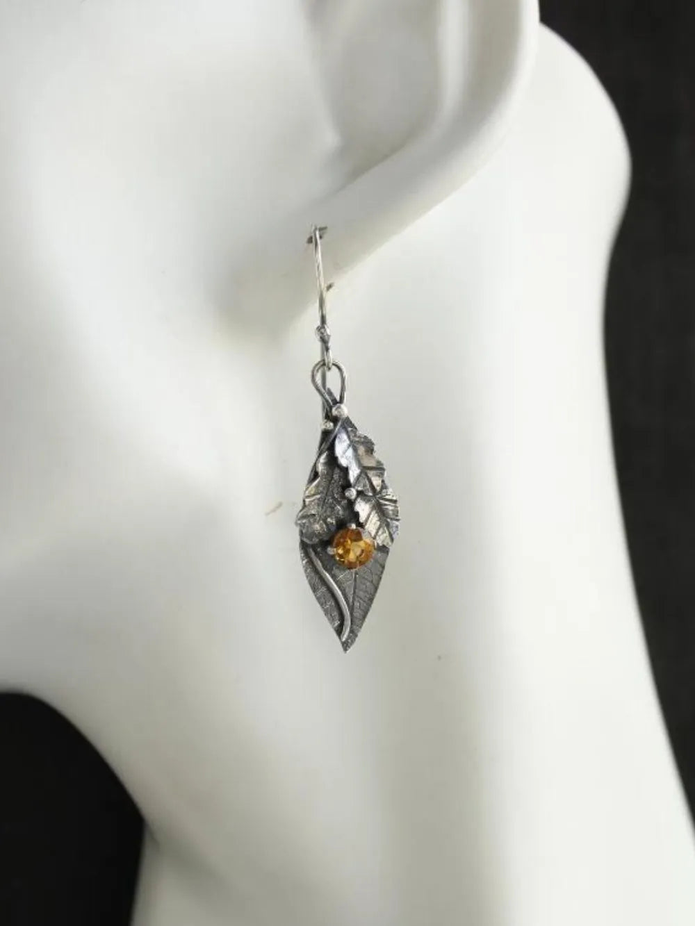 Textured leaf citrine drop earrings with yellow stone and silver tone metal.