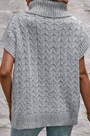 Gray cable knit turtleneck capelet sweater with short sleeves and ribbed trim.