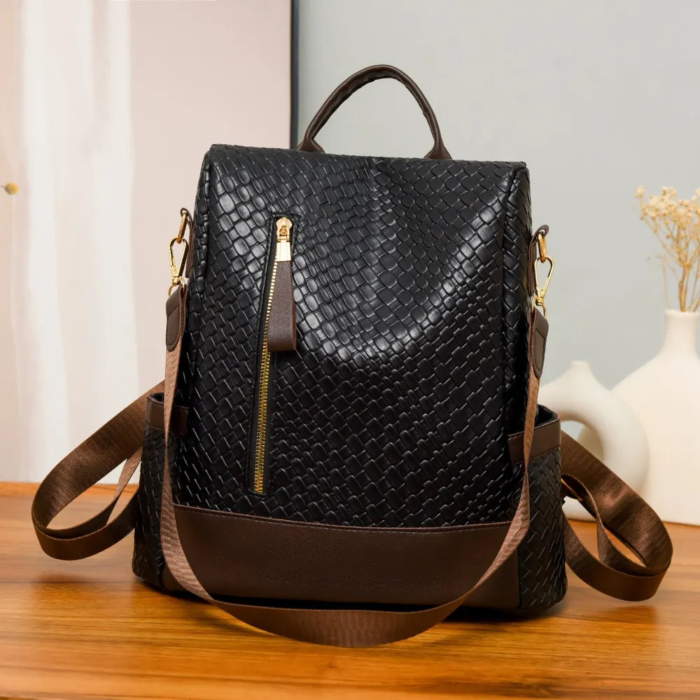 Black woven faux leather convertible backpack with gold zipper detail and brown trim.