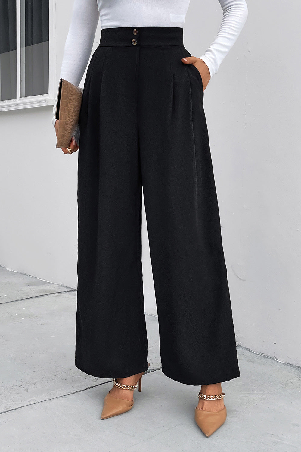 Black high-rise ruched wide-leg trousers with button detail and pockets.