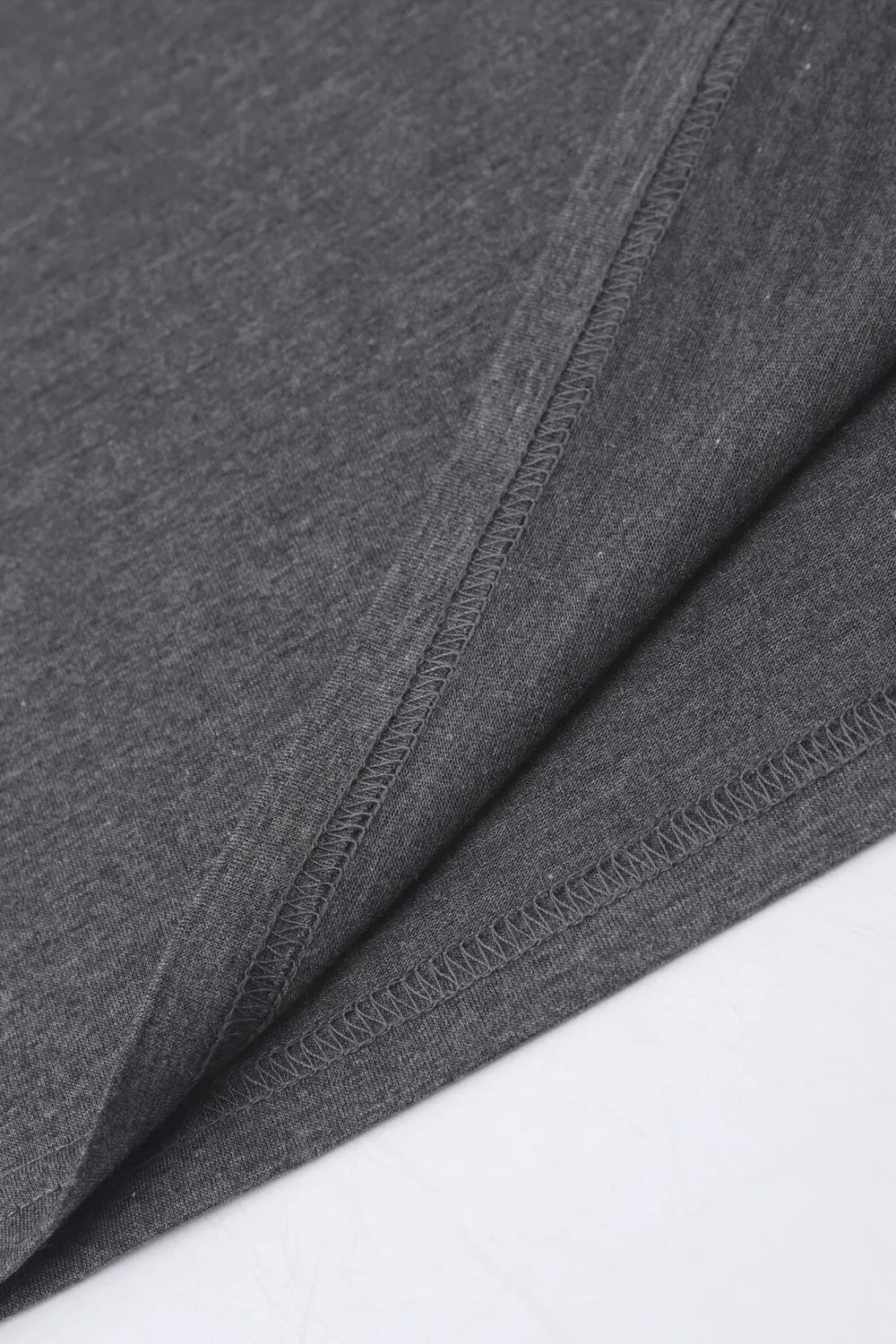 Dark gray t-shirt detail showing hem and side seam stitching