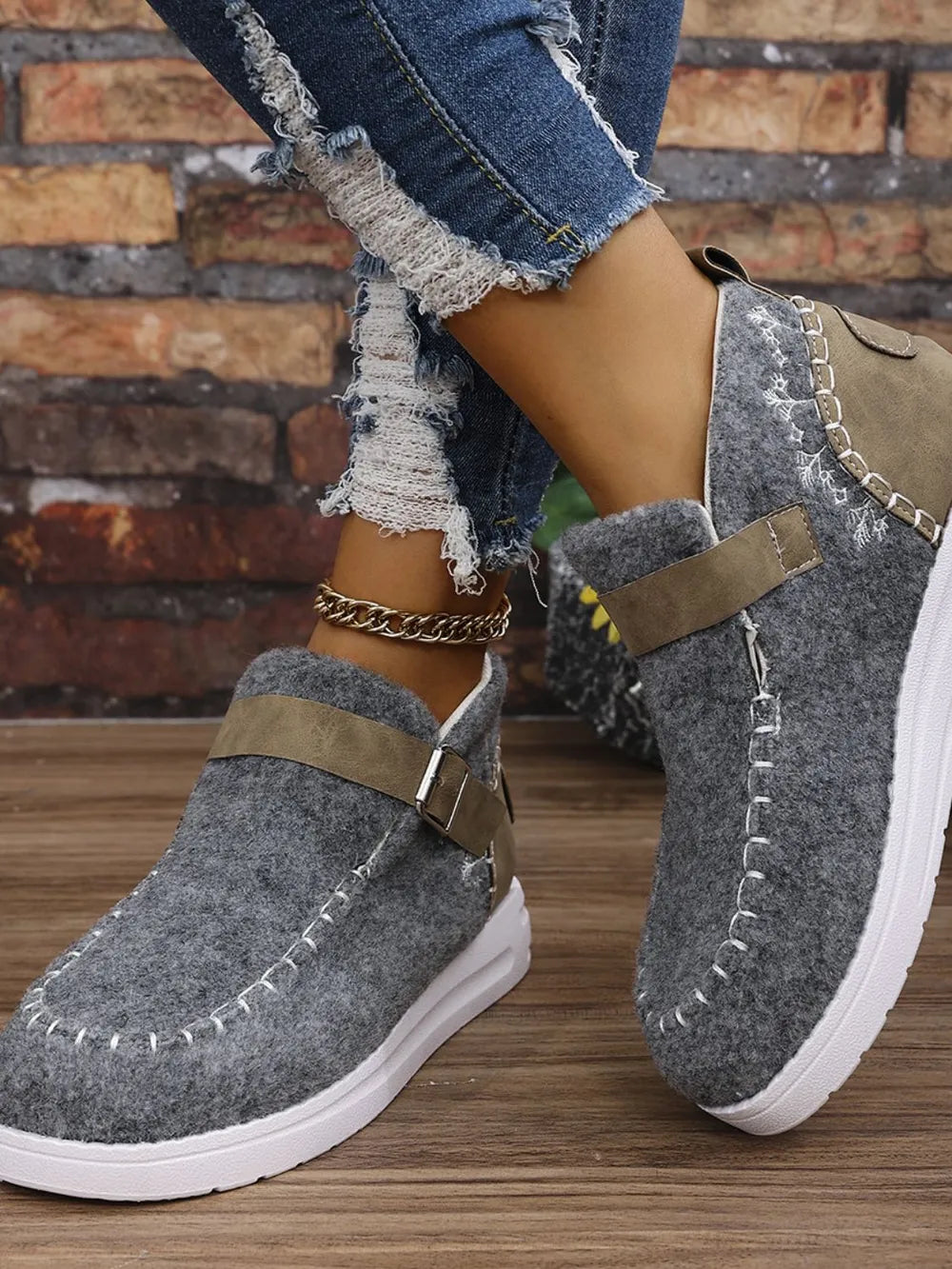 Gray textured stitch-detail buckle sneakers with white contrast stitching and a brown strap detail.