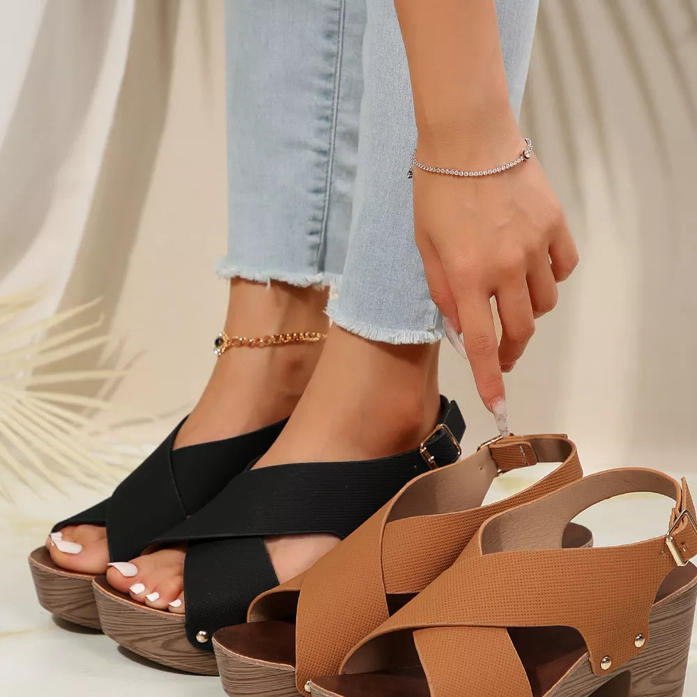 Crisscross high heel sandals in black and brown with stud details and adjustable straps.