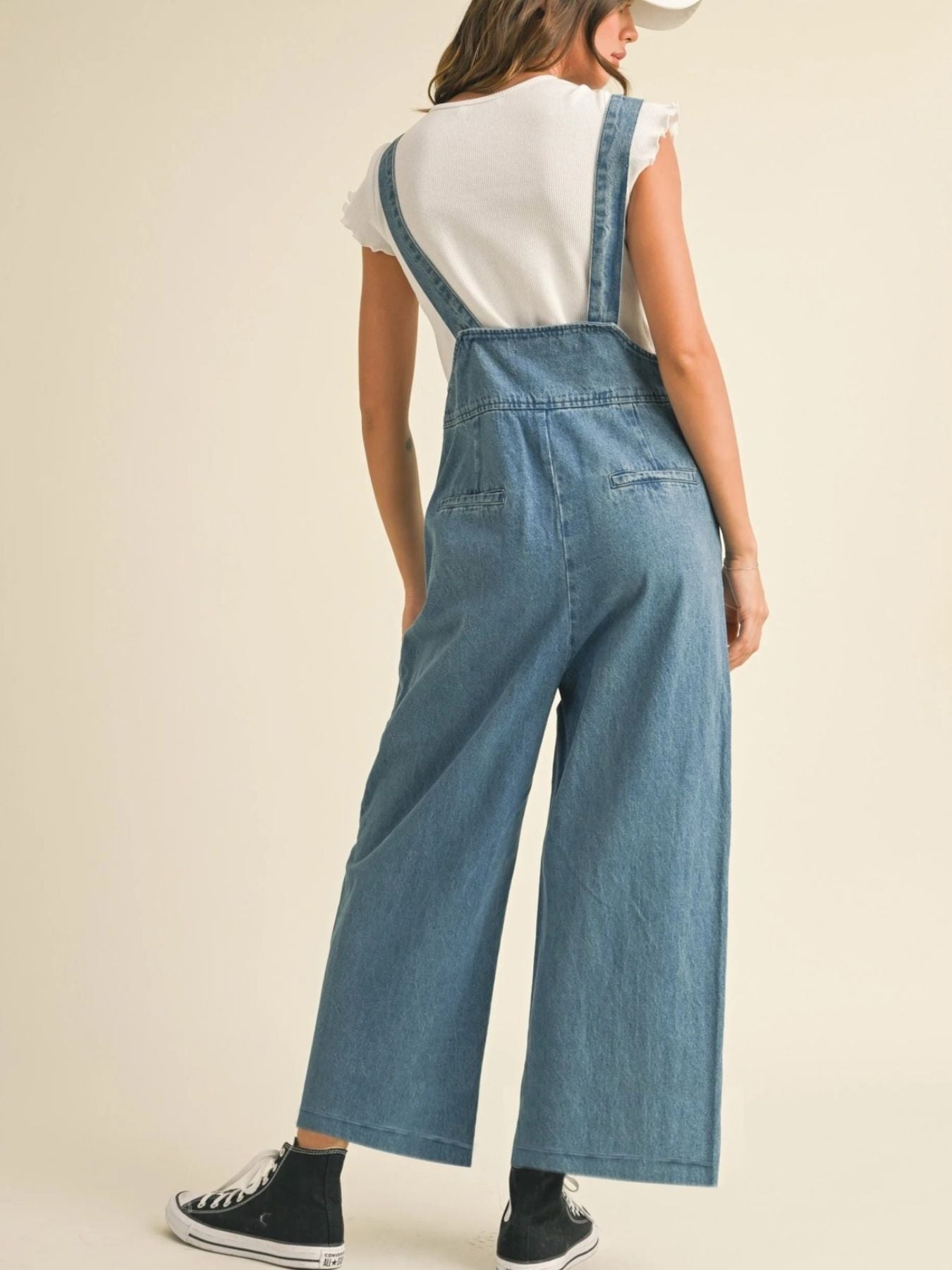 Vintage denim wide leg overalls with adjustable straps and button details.