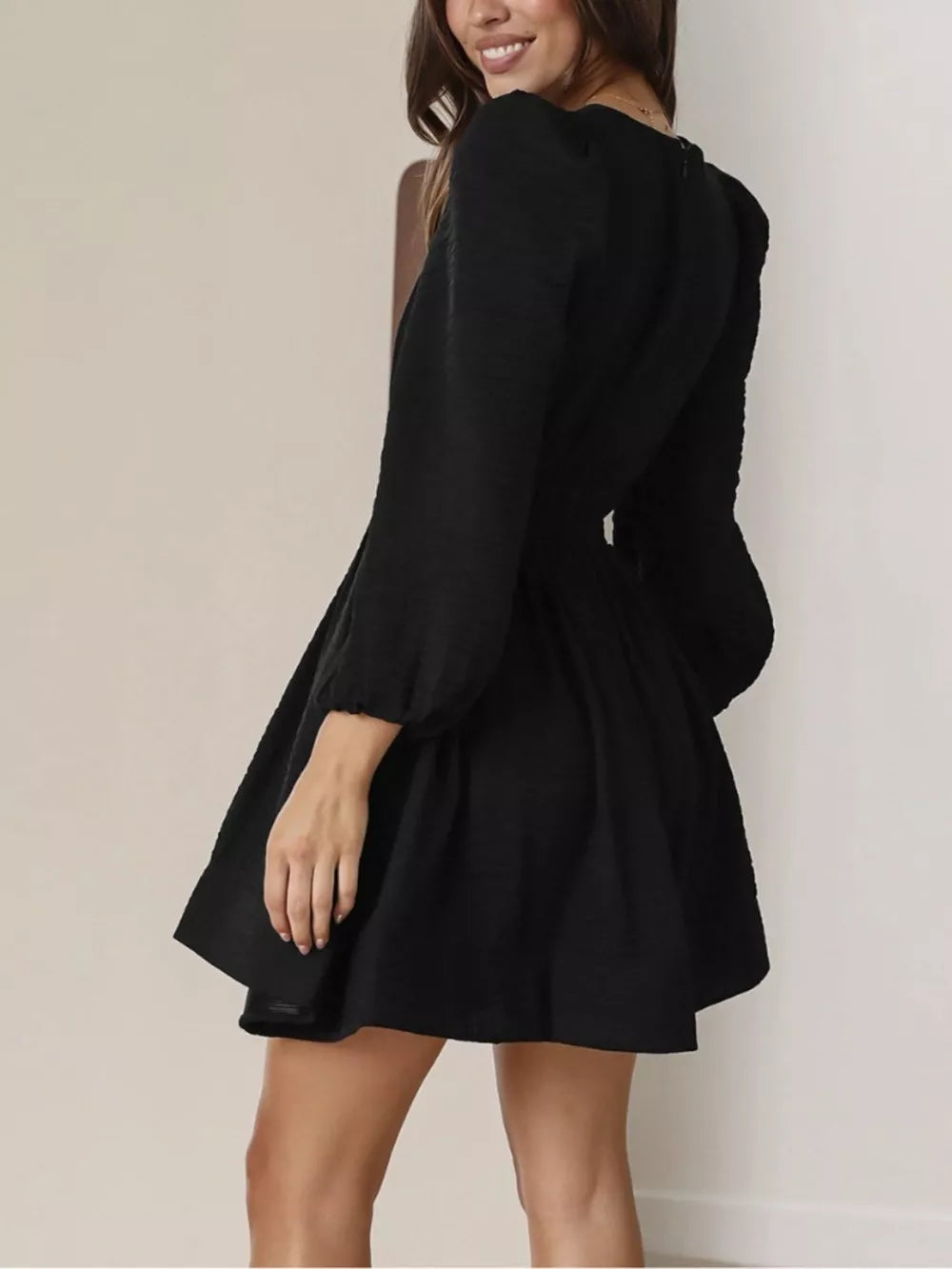 Black V-neck mini dress with puff sleeves and textured fabric