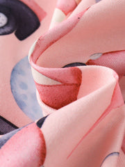 Pink children's one-piece with playful golf ball pattern detail