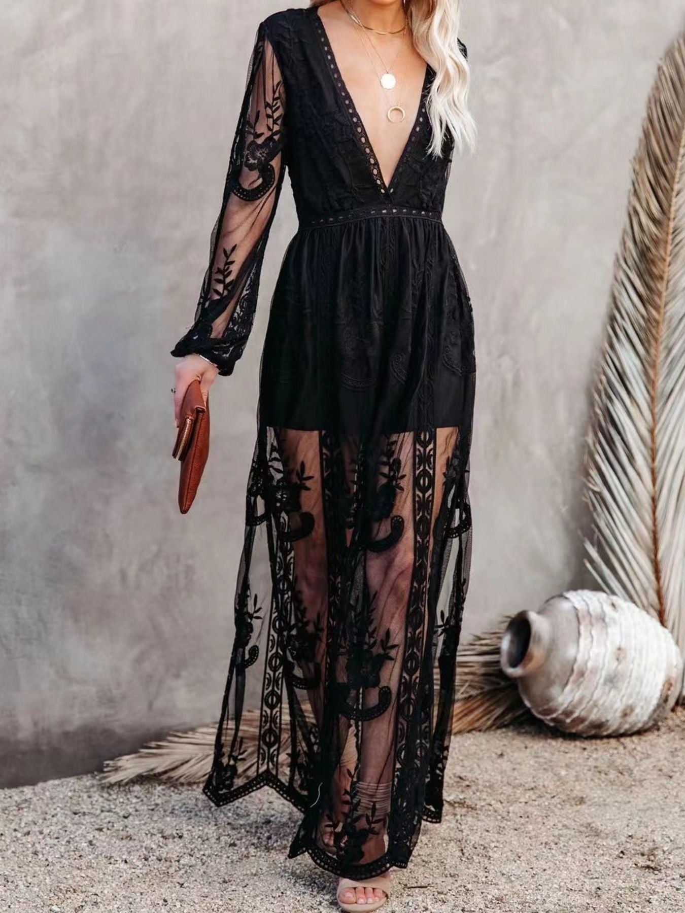 Black floral lace maxi dress with plunging neckline, long sleeves, and a slit.