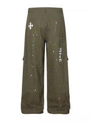 Olive cotton cargo pants with white paint splatter design and graphic text detail.