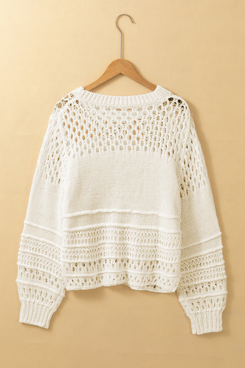 Ivory openwork knit pullover sweater with balloon sleeves and textured details.