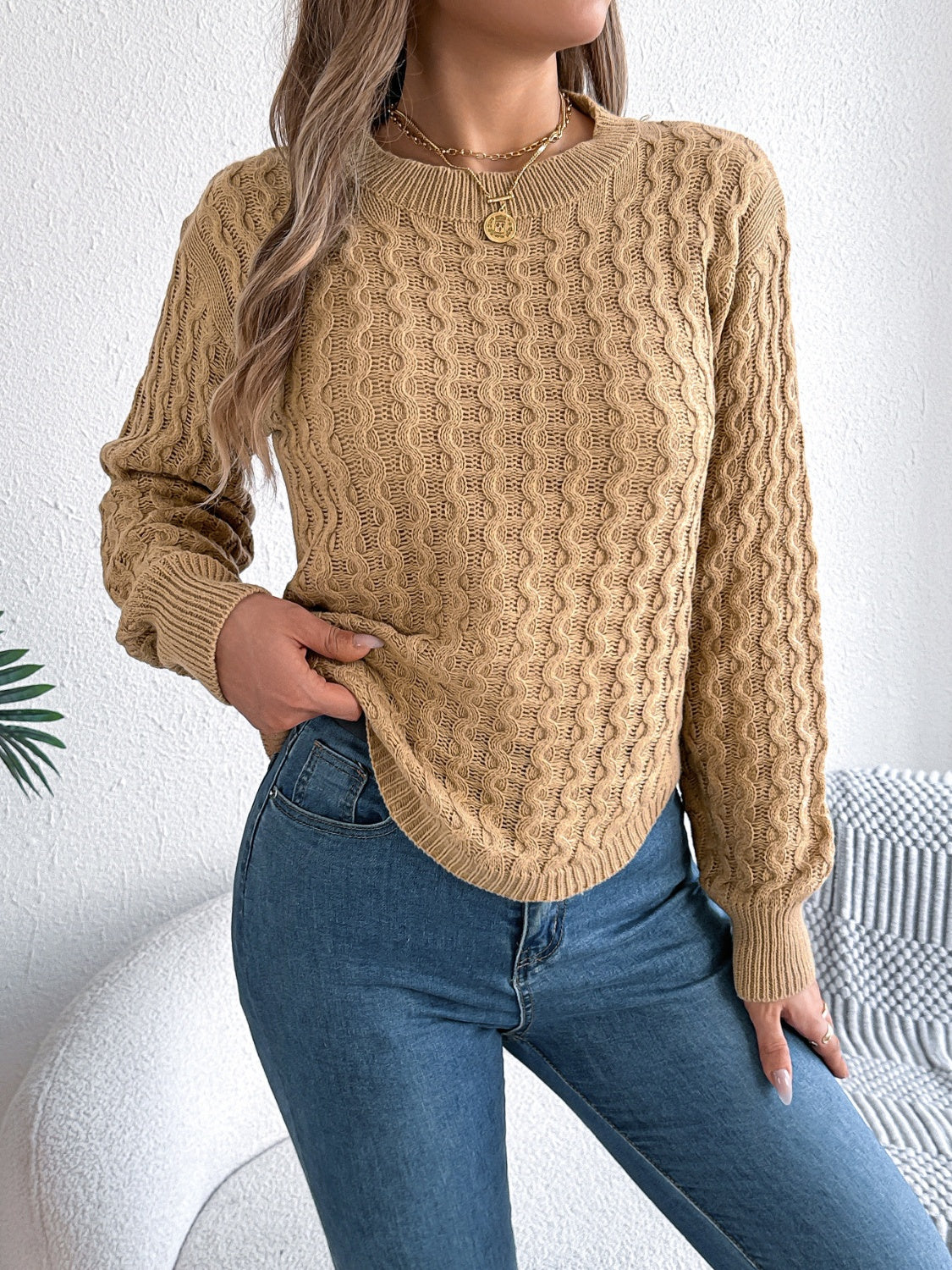 Camel acrylic cable knit sweater with asymmetric hem and crew neck.