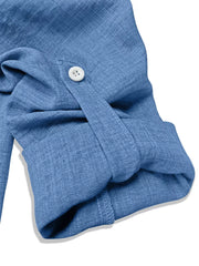 Blue textured casual shirt with roll-tab sleeves and a white button detail.