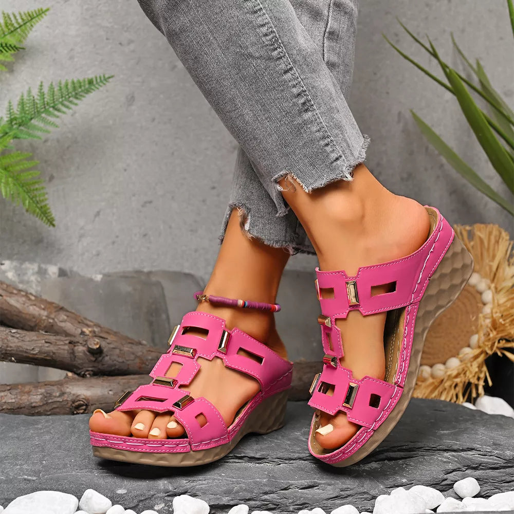 Pink open-toe wedge sandals with geometric cutouts and gold accents.