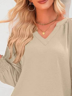 Khaki polyester blouse with smocked long sleeves and V-neckline.