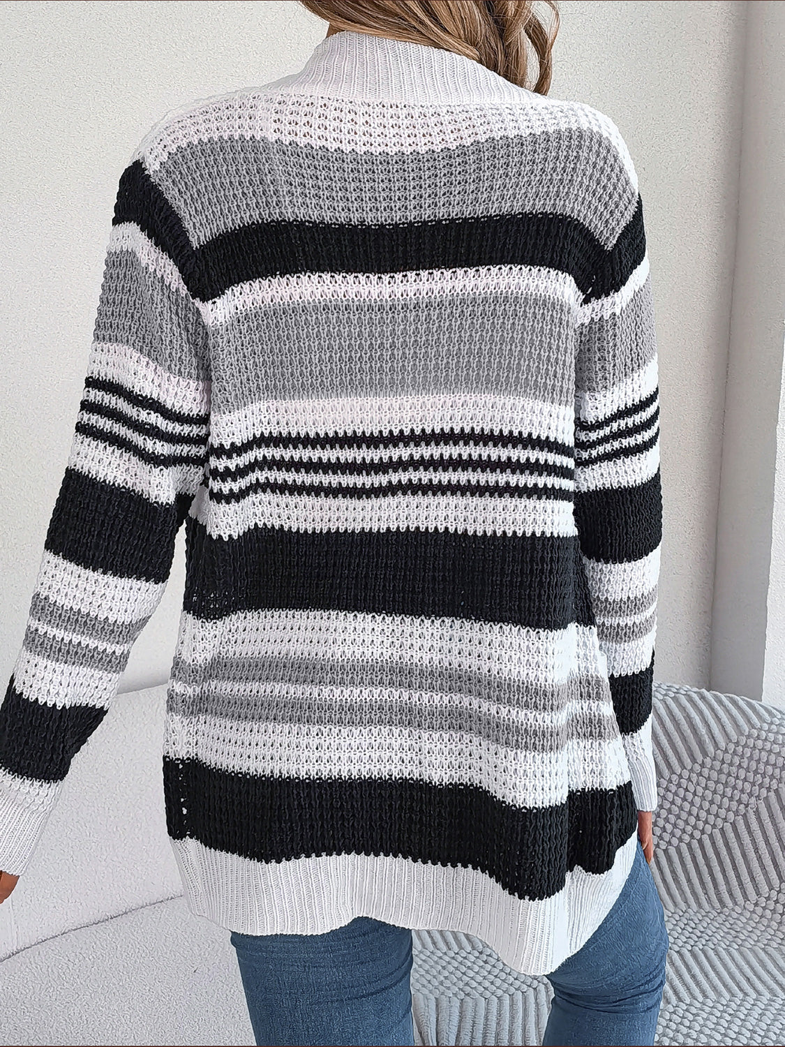 Colorblock open-front knit cardigan with horizontal stripes in black, white, and gray.
