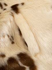 Cropped faux fur jacket in beige with brown spots, showing textured material.