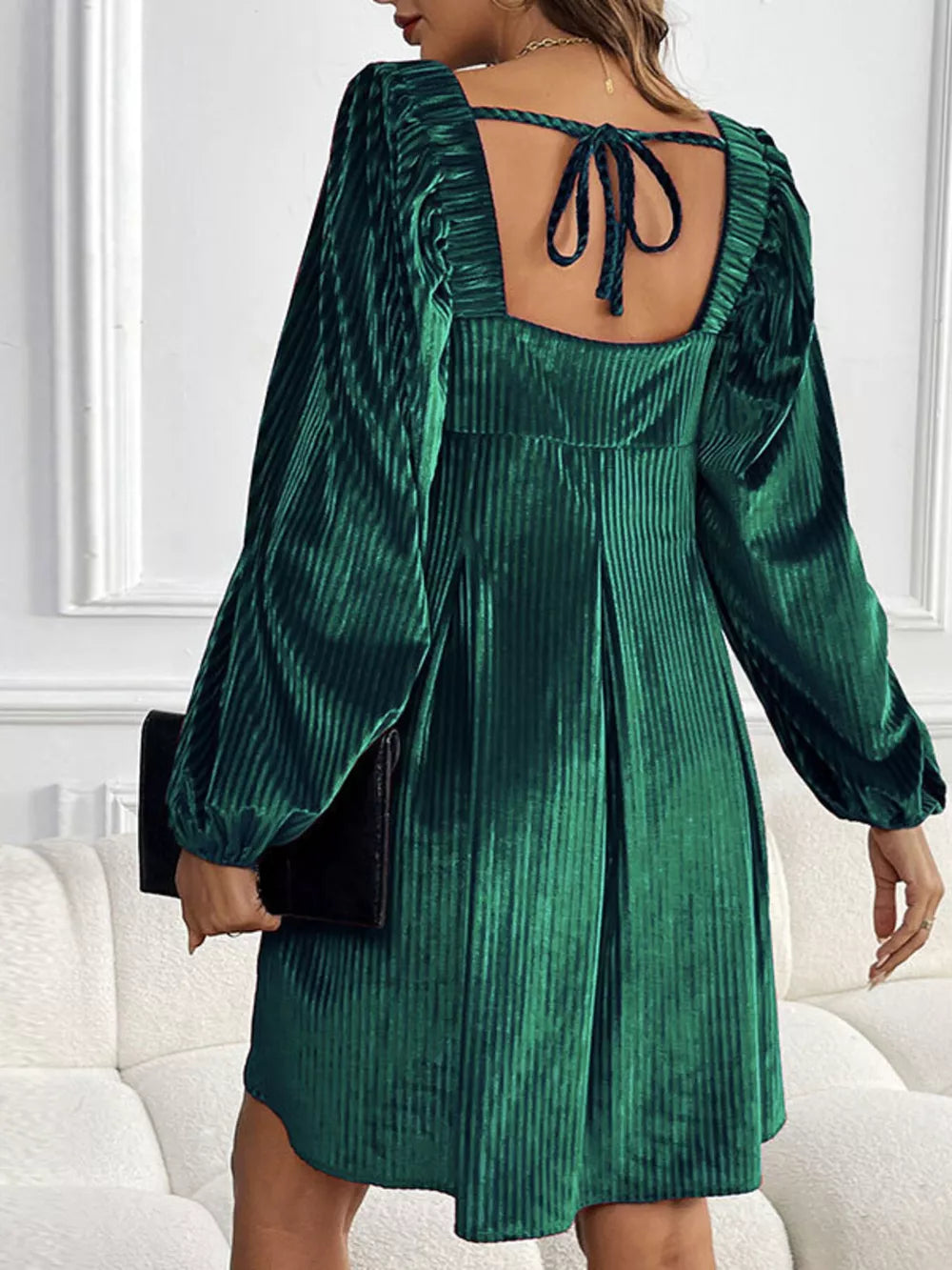 Dark green velvet mini dress with square neckline, puff sleeves and tie back detail.