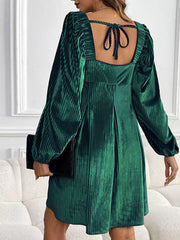 Dark green velvet mini dress with square neckline, puff sleeves and tie back detail.